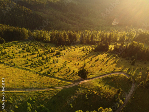 Aerial view of beautiful mountain Carpathians, Ukraine in sunlight. Drone filmed an landscape with coniferous and beech forests, around a winding serpentine road, copter aerial photo photo