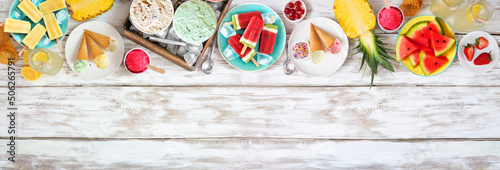 Cool summer treats top border. Different ice cream, popsicles and fruit. Overhead view on a white wood banner background.