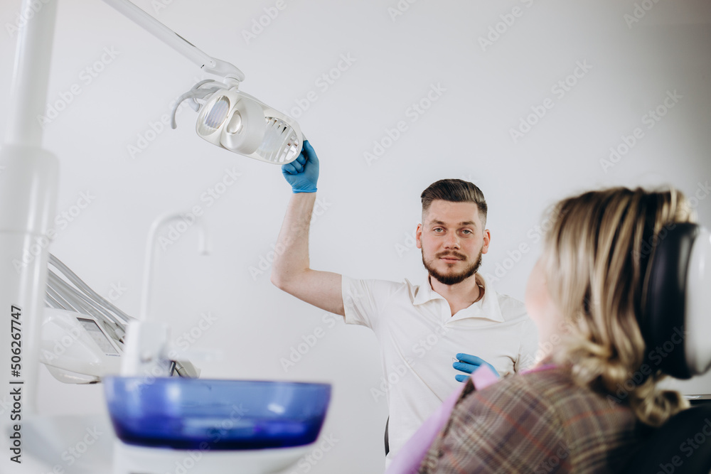 Male dentist using digital tablet and talking to his patient at dental clinic. Male dentist using digital tablet and talking to his patient at dental clinic.