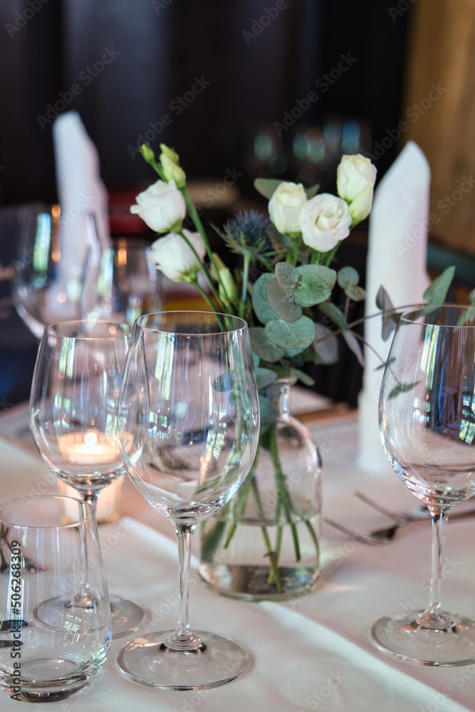 Table arranged for a formal dinner with candles and flowers on a white table cloth. Table arranged for a formal dinner with candles and flowers on a white table cloth.