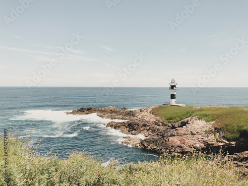 Beautiful lighthouse in front of the sea, located in Isla Pancha, Ribadeo. Concept holidays, travel, adventure, summer. photo