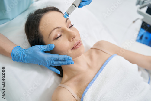 Woman receiving skincare treatment in cosmetology clinic