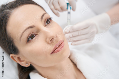 Woman receiving facial beauty injection in cosmetology clinic