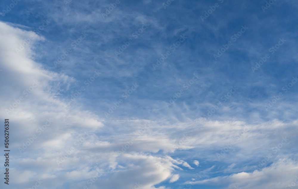 Blue sky with white clouds in sunlight, wide cloudscape background Blue sky with white clouds in sunlight, wide cloudscape background