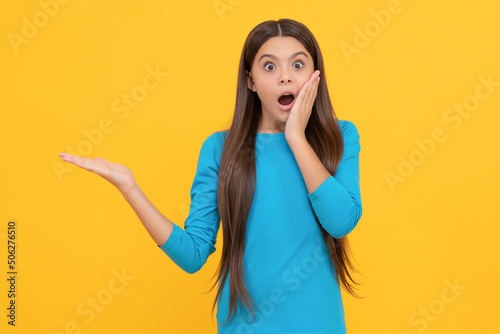 shocked face portrait of child on yellow background. express positive emotions