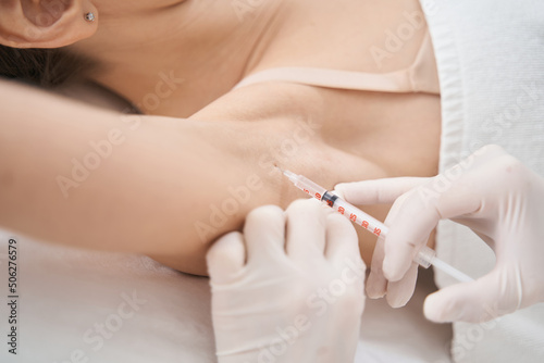 Woman receiving underarm injection in beauty salon