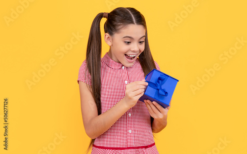 surprised child hold gift box on yellow background, womens day © Olena