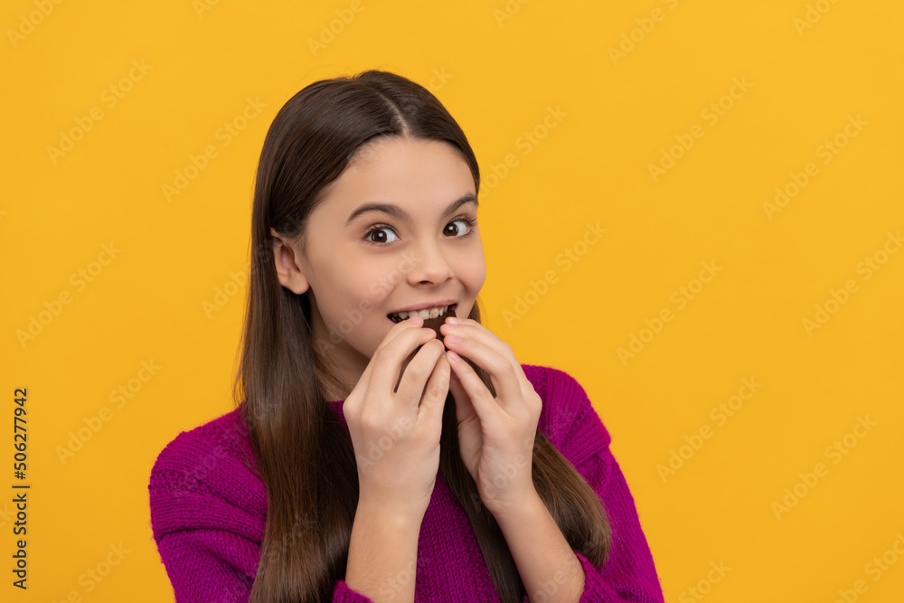 Happy kid bite tasty chocolate snack yellow background, eating Happy kid bite tasty chocolate snack yellow background, eating