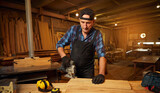 Senior Professional carpenter in uniform sawing wood with an electric jigsaw in the carpentry workshop