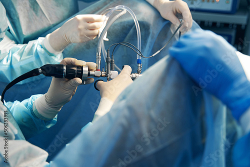 Laparoscope with tubes in hand of professional surgeon photo