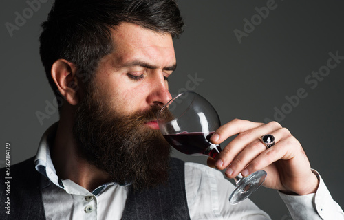 Bearded man with glass of red wine. Tasting alcohol. Sommelier, degustator. Winery, male winemaker.