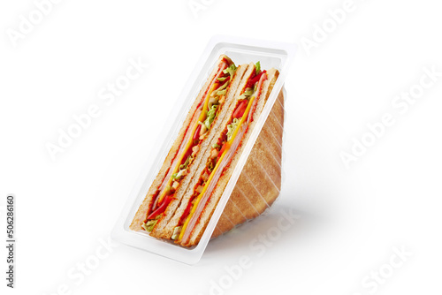 Delicious sandwiches with ham and vegetables in container
