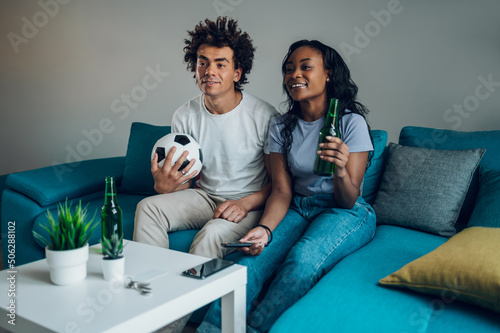Fotobehang African american couple drinking beer and watching the football game at home