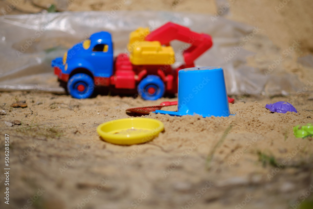 Children's toys in the sandbox, excavator, bucket, side view Children's toys in the sandbox, excavator, bucket, side view