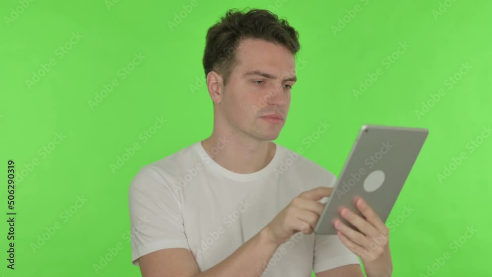 Young Man using Digital Tablet on Green Background Young Man using Digital Tablet on Green Background