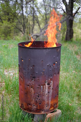 Flames spreading out from a fire 
 metal barrel 