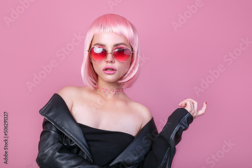 Stylish portrait of woman in sunglasses with bright colored pink hair and pink make-up in sunglasses
