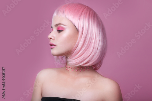 Close-up portrait of woman with bright colored pink hair and pink make-up. Professional coloring
