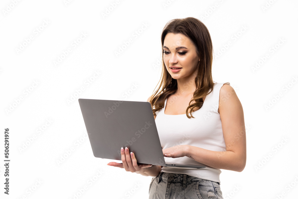 Naklejka premium Portrait of young office woman, entrepreneur answer clients on laptop standing over white background