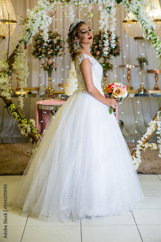 Fototapeta premium young caucasian brazilian bride at her wedding with decorated background, makeup and hairstyle.