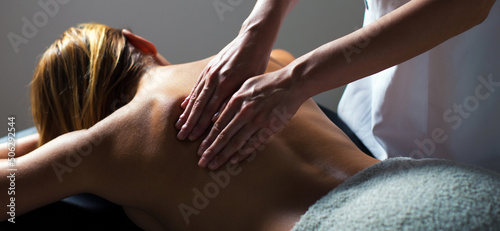 Girl enjoying back massage in massage salon