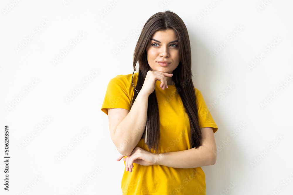 Smiling woman in eyeglasses posing with crossed arms and looking at the camera over white background