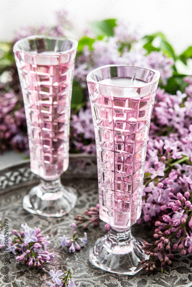 Two glasses of rose wine and lilac bouquet, selective focus Two glasses of rose wine and lilac bouquet, selective focus