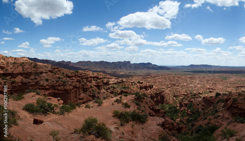 Panorama view of the red canyon. View of the red desert, rock and sandstone cliffs, valley and mountains under a beautiful sky. 