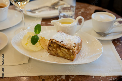 Austrian sweet dessert  portion of apple strudel with whippen cream and hot vanilla sauce served in old bakery cafe in Vienna  Austria