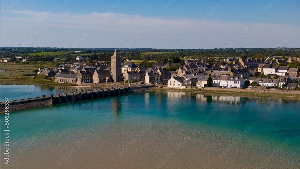 View of Church at Portbail from the bridge with a reflection of the church in the water