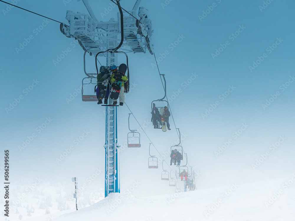athletes climb on a chair lift for skiing and snowboarding athletes climb on a chair lift for skiing and snowboarding
