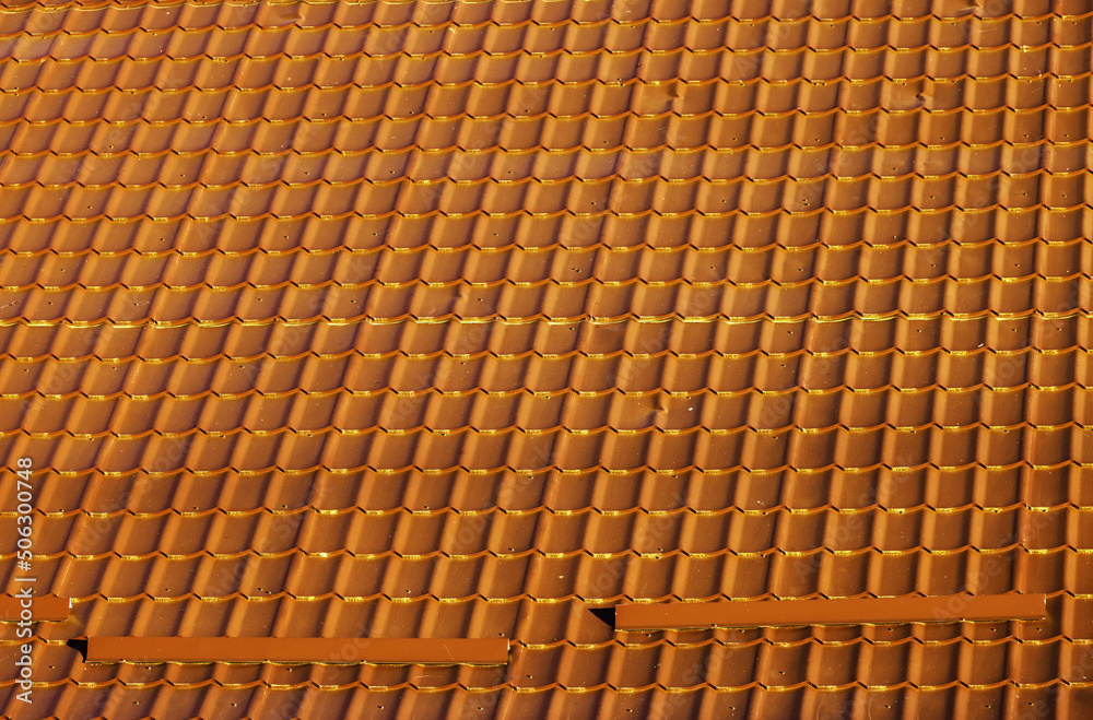Red corrugated metal profile roof installed on a modern house. The roof of corrugated sheet. Roofing of metal profile wavy shape. Modern roof made of metal. Metal roofing. Red corrugated metal profile roof installed on a modern house. The roof of corrugated sheet. Roofing of metal profile wavy shape. Modern roof made of metal. Metal roofing.
