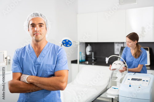 Portrait of confident professional male cosmetologist in modern clinic of aesthetic medicine