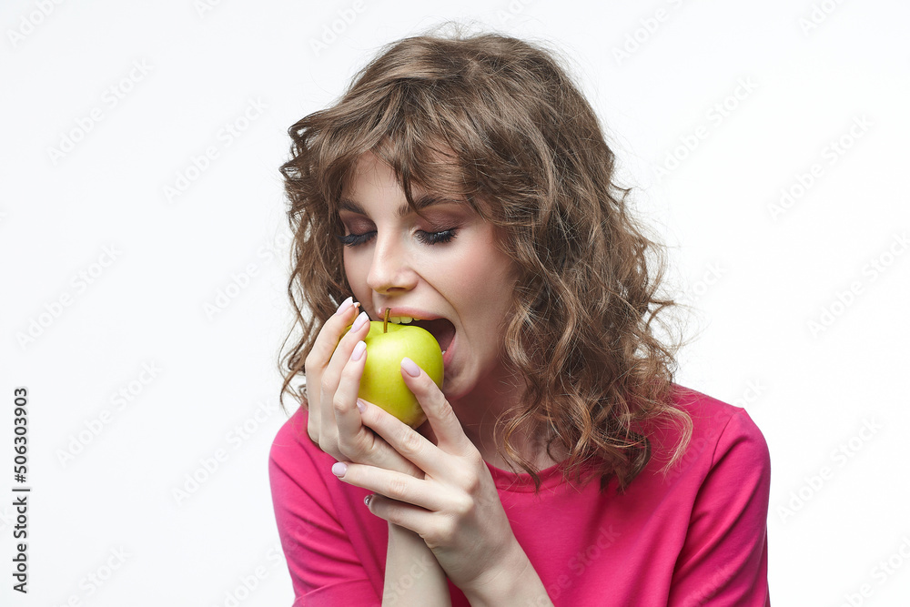 attractive girl is going to bite off a ripe green apple. attractive girl is going to bite off a ripe green apple.