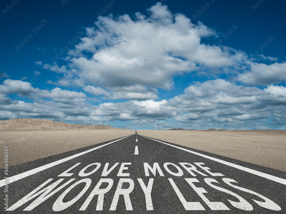 Love More Worry Less inspirational quote on highway background.