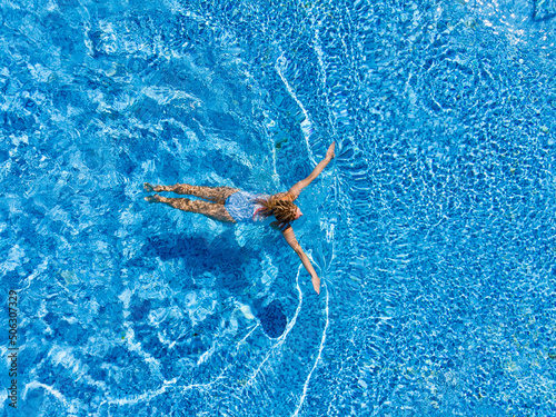 Aerial top view of woman in swimming pool water from above  summer vacation holiday concept  drone view
