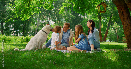 Fotografie Young family caress labrador on picnic