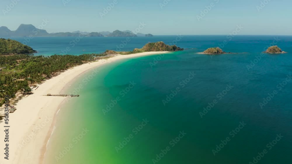 Aerial view of tropical island with sandy beach. Nacpan, El Nido, Palawan, Philippines. Seascape with sea, sand, palm trees. Summer and travel vacation concept Aerial view of tropical island with sandy beach. Nacpan, El Nido, Palawan, Philippines. Seascape with sea, sand, palm trees. Summer and travel vacation concept
