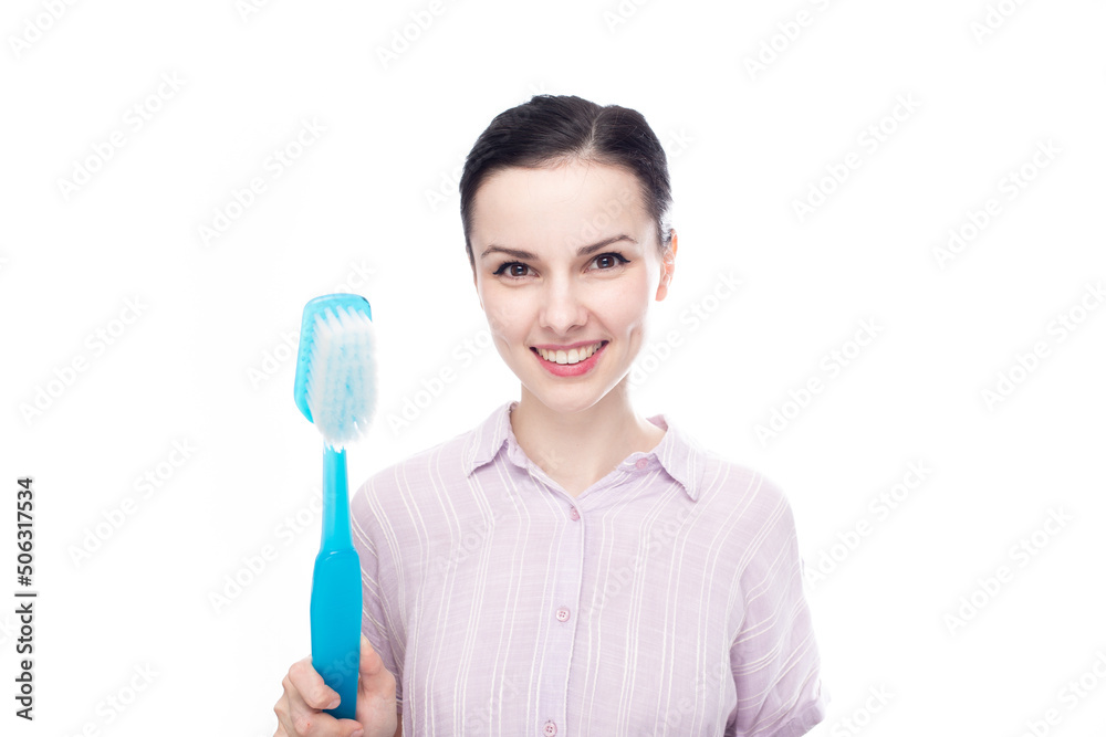joyful woman in a purple shirt holding a huge blue toothbrush in her hands, white background joyful woman in a purple shirt holding a huge blue toothbrush in her hands, white background