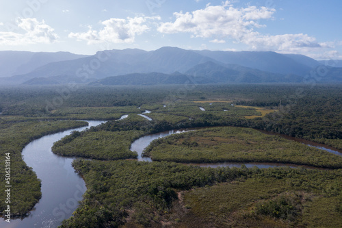 imagem aérea das águas do rio itaguaré sobre a mata atlântica com algumas montanhas ao fundo 