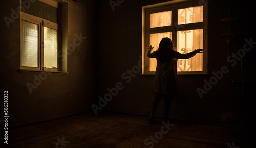 Horror woman in window wood hand hold cage scary scene halloween concept Blurred silhouette of witch. Horror theme