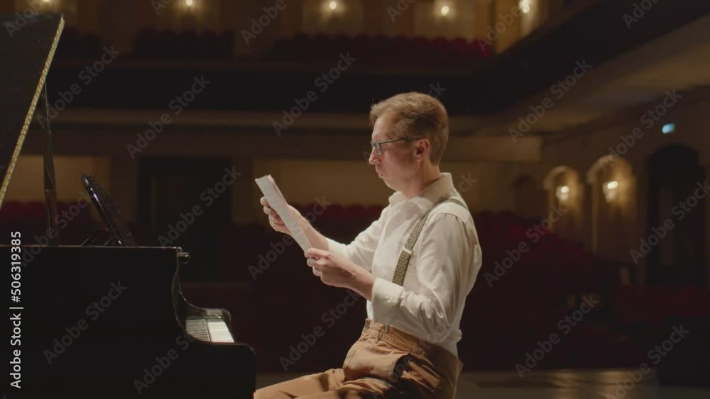 Arc slow mo shot of pianist throwing away sheet music and playing grand