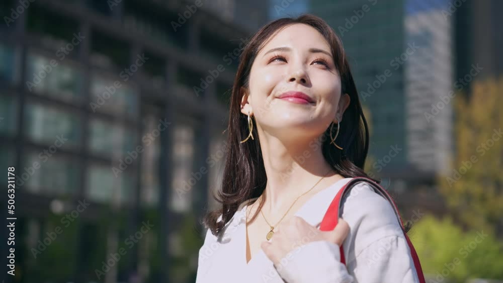 街中で空を見上げる女性