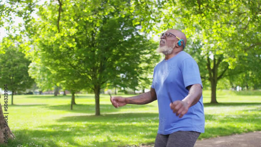 Healthy senior black man exercises in a park with a skipping rope, in slow motion Healthy senior black man exercises in a park with a skipping rope, in slow motion