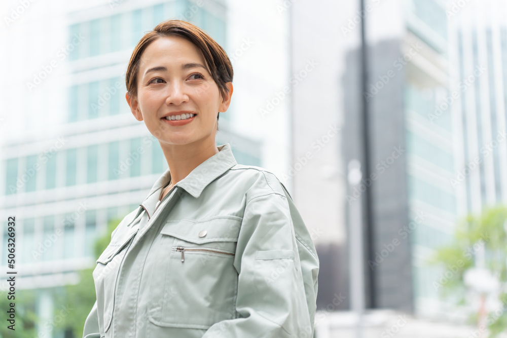 空を見る作業着を着た爽やかな日本人女性