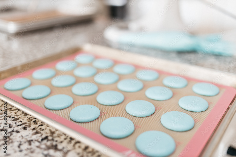 Bakery. Making macaroons. Blue macarons ready for baking lie on a tray on a wooden table. Biscuit Bakery. Making macaroons. Blue macarons ready for baking lie on a tray on a wooden table. Biscuit