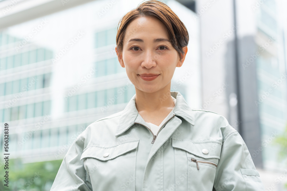 カメラを見る作業着を着たショートヘアーの日本人女性 カメラを見る作業着を着たショートヘアーの日本人女性