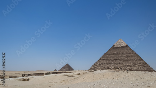 Architectural detail of the Giza pyramid complex located about 13 kilometers southwest of Cairo s city center. In the background  the Pyramid of Khafre or of Chephren