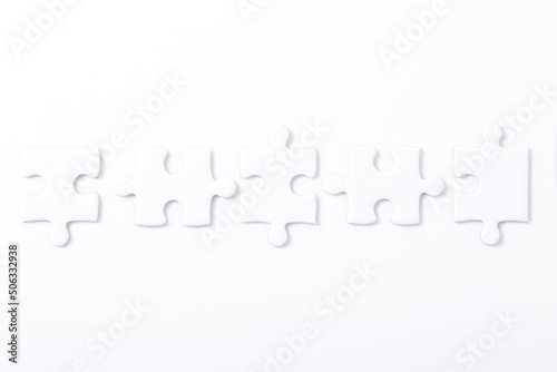 Five white puzzle pieces on a white background.