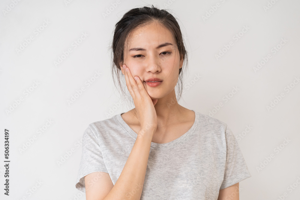 Closing eyes asian young woman touching cheek, face expression from toothache, tooth decay or sensitivity, Having tooth or teeth problem or inflammation, suffering from health. Sensitive teeth people Closing eyes asian young woman touching cheek, face expression from toothache, tooth decay or sensitivity, Having tooth or teeth problem or inflammation, suffering from health. Sensitive teeth people